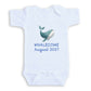 A white baby onesie with a graphic of a whale and the text "Whalecome August 2027" printed on it.