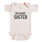 A baby onesie with the text "middle SISTER" printed on it.