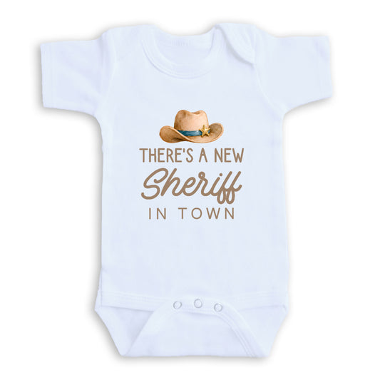 A white baby onesie with a cowboy hat and text printed on it.