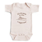 A pink colored baby bodysuit with the words "We are going to need a bigger boat"  and a sea vessel embroidered on the front in gold thread