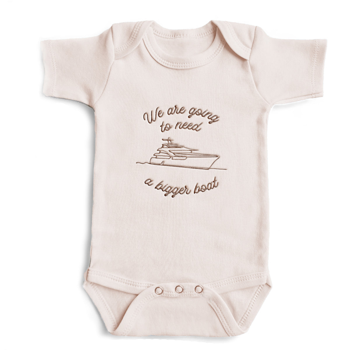 A pink colored baby bodysuit with the words "We are going to need a bigger boat"  and a sea vessel embroidered on the front in gold thread