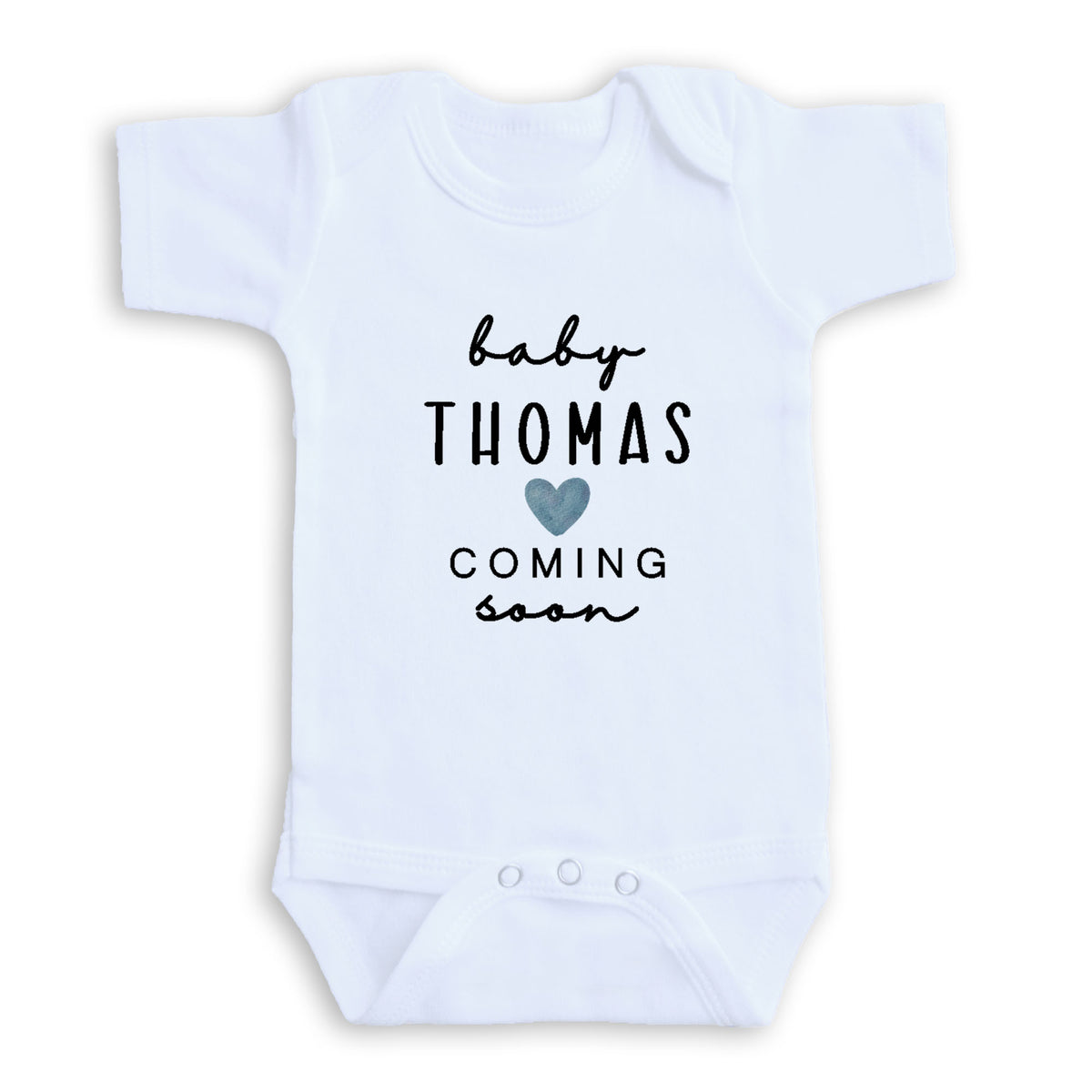 A white baby onesie with the text "baby Thomas coming soon" printed on it.
