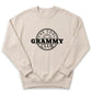 A beige sweatshirt with a black graphic design on it. The design features the text "THE COOL GRAMMY CLUB" in a circular shape.