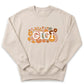 A beige sweatshirt with a floral design and the word "GIGI" printed on it.