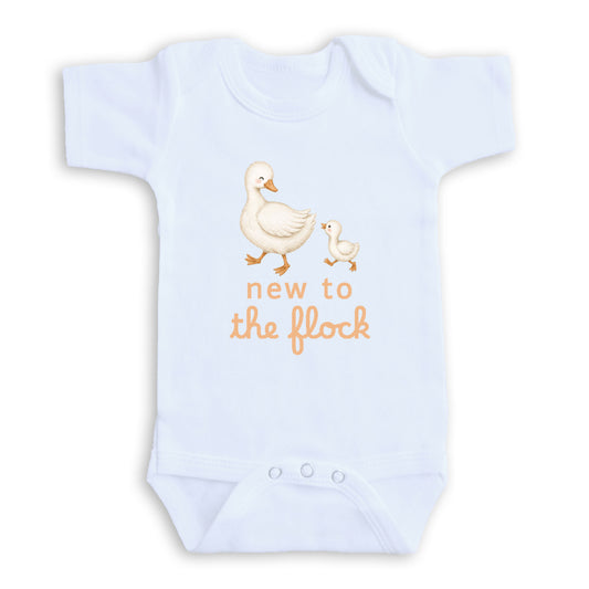 A white baby onesie with an illustration of a mother duck and her duckling, along with the text "new to the flock" printed on it.