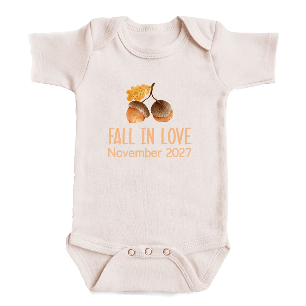 A baby onesie with an acorn and leaf design, along with the text "FALL IN LOVE November 2027".