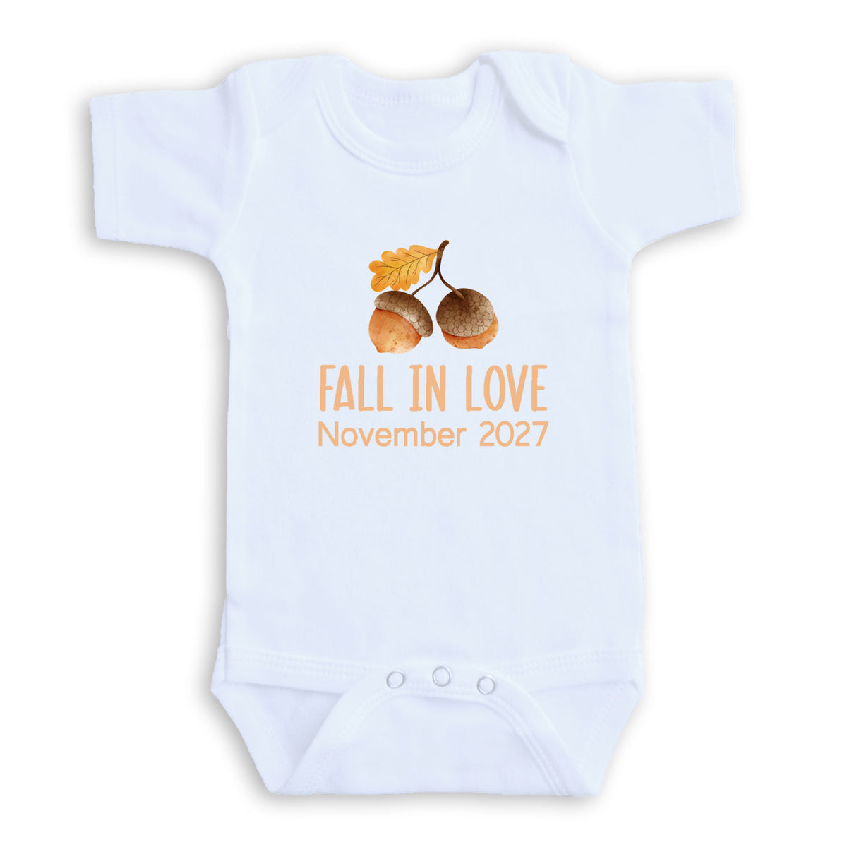 A white baby onesie with an image of acorns and the text "FALL IN LOVE November 2027" printed on it.