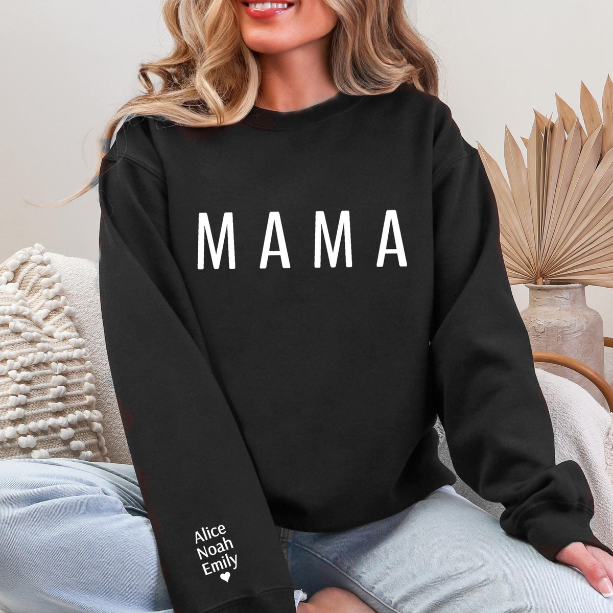 A woman wearing a black sweatshirt with the word "MAMA" printed on it.