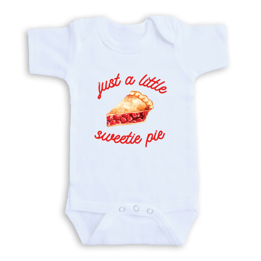 A white baby onesie with a red and white design featuring a slice of pie and the text "Just a little sweetie pie" printed on it.