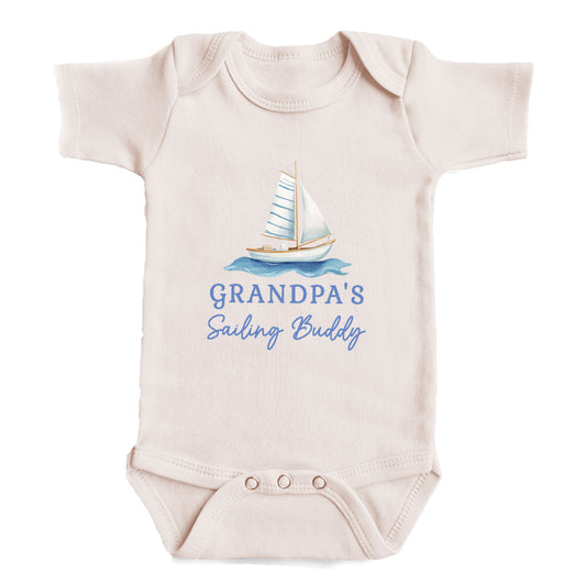 A baby onesie with a sailboat graphic and the text "GRANDPA'S Sailing Buddy" printed on it.