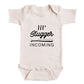 A baby onesie with the text "11'll Slugger INCOMING" printed on it.