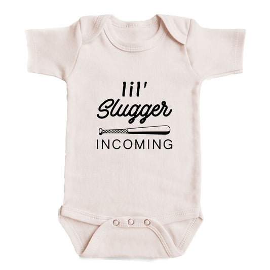 A baby onesie with the text "11'll Slugger INCOMING" printed on it.