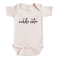 A baby onesie with the text "middle sister" printed on it.