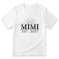 A white t-shirt with a graphic design featuring the text "Mimi EST. 2027" and a sun-like symbol.