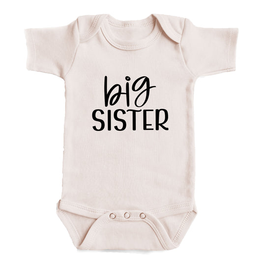 A baby onesie with the text "big sister" printed on it.