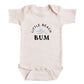 A baby onesie with the text "LITTLE BEACH BUM" printed on it.