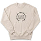 A beige sweater with a circular design featuring the word "NANA" in the center.