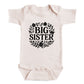 A baby onesie with the text "BIG SISTER" printed on it.