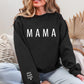 A woman wearing a black sweatshirt with the word "MAMA" printed on it.