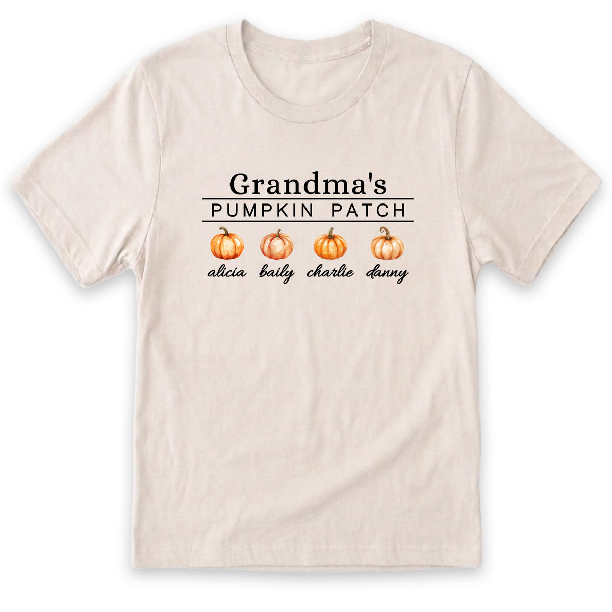 A beige t-shirt with the text "Grandma's PUMPKIN PATCH" printed on it, along with three orange pumpkins.