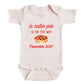 A baby onesie with a printed message on it.