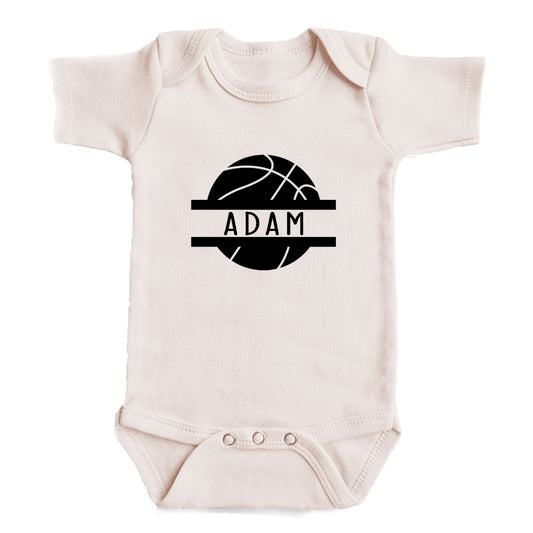 A white baby onesie with a black basketball graphic and the name "ADAM" printed on it.