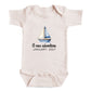 A baby onesie with a sailboat graphic and the text "A new adventure JANUARY 2027" printed on it.
