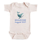 A baby onesie with a graphic of a whale and the text "Whalecoming August 2027" printed on it.