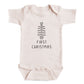 A baby onesie with a Christmas tree design and the text "FIRST CHRISTMAS" printed on it.