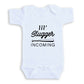 A white baby onesie with the text "I'll Slugger Coming" printed on it.