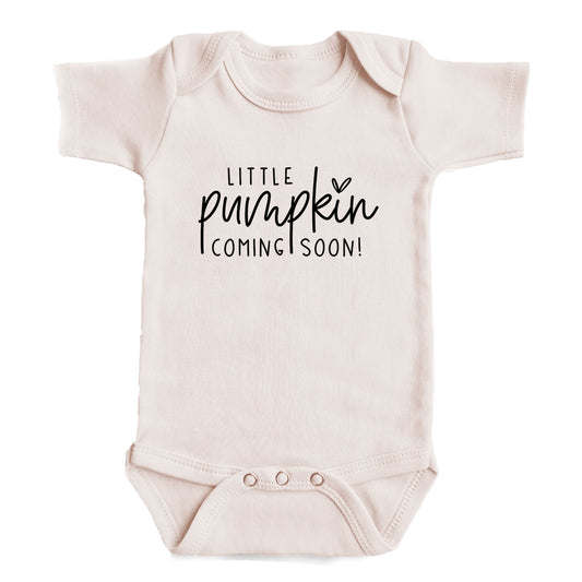 A baby onesie with the text "Little pumpkin coming soon!" printed on it.