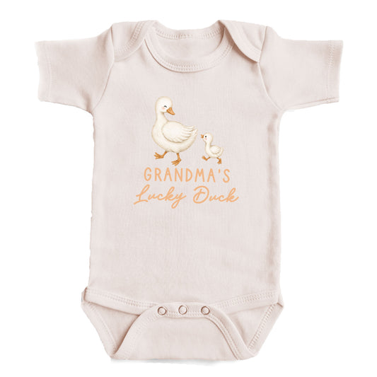 A baby onesie with a cartoon image of a duck and the text "GRANDMA'S LUCKY DUCK" printed on it.