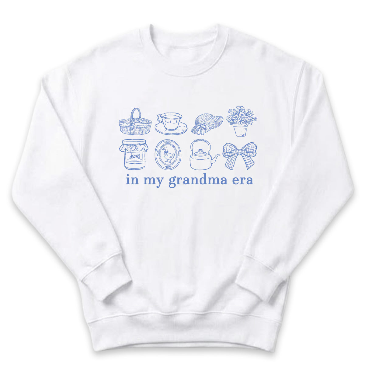 A white sweatshirt with a graphic design featuring various objects such as a basket, teapot, vase, and a clock, along with the text "in my grandma era" printed on it.