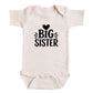 A baby onesie with the text "BIG SISTER" printed on it.