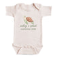 A baby onesie with a turtle graphic and the text "making a splash september 2028" printed on it.
